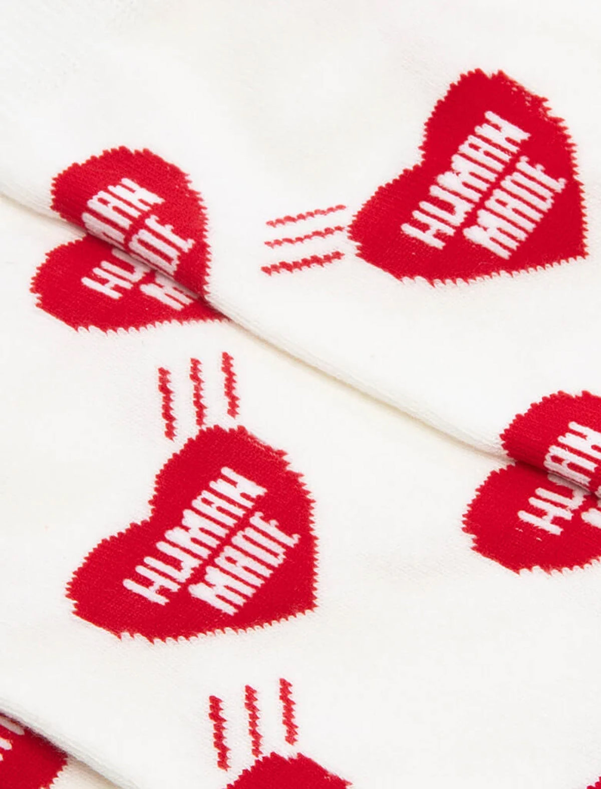 HEART SOCKS: White socks featuring a repeating Human Made heart logo pattern, with each heart printed with the words HUMAN MADE.