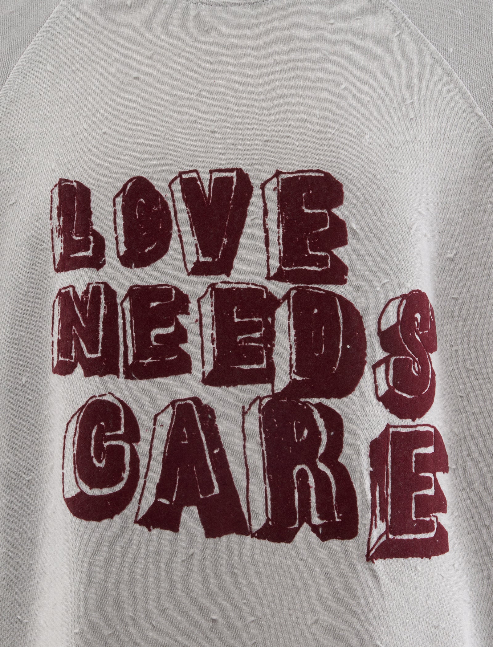 LOVE NEEDS CARE CREWNECK