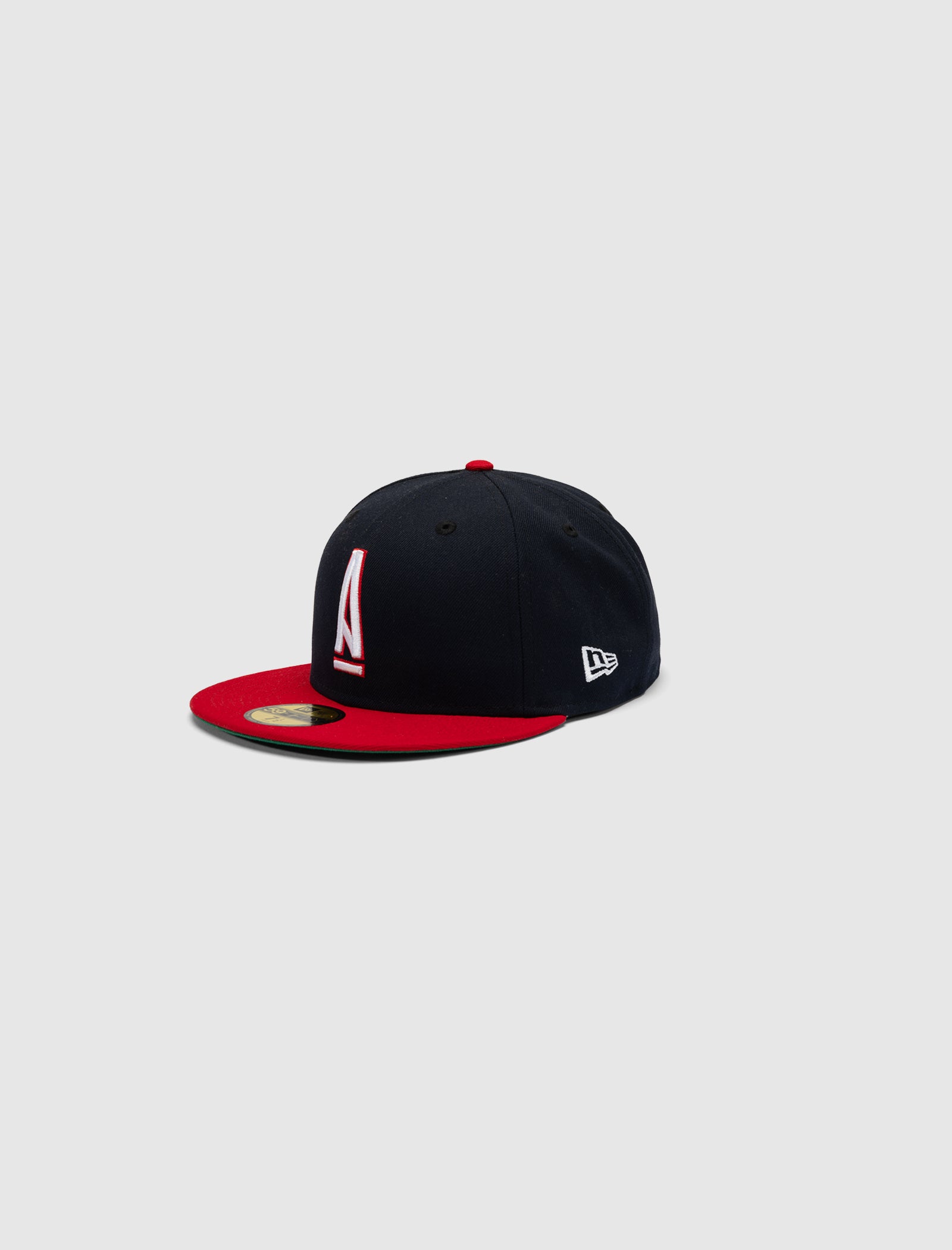 The A MA MANIÉRE 5950 A LOGO HAT is black with a red brim and button, featuring a white and red front logo and a small white New Era logo on the side, shown against a plain light gray background.