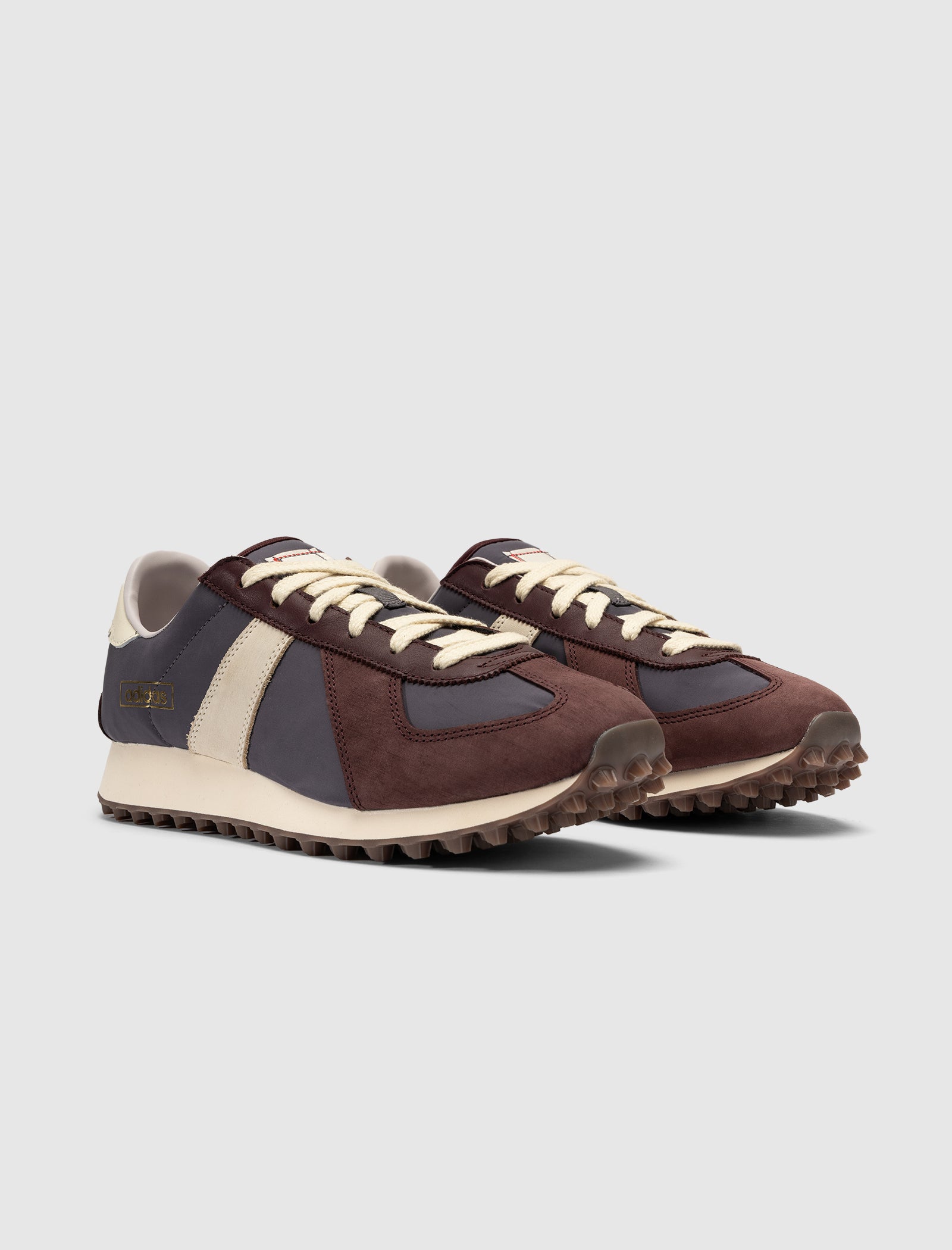 The DND BW RUN HARLEM'S BEST features a retro low-top design with burgundy, navy blue, and cream panels, cream laces, and textured brown soles, showcased against a plain light gray background.