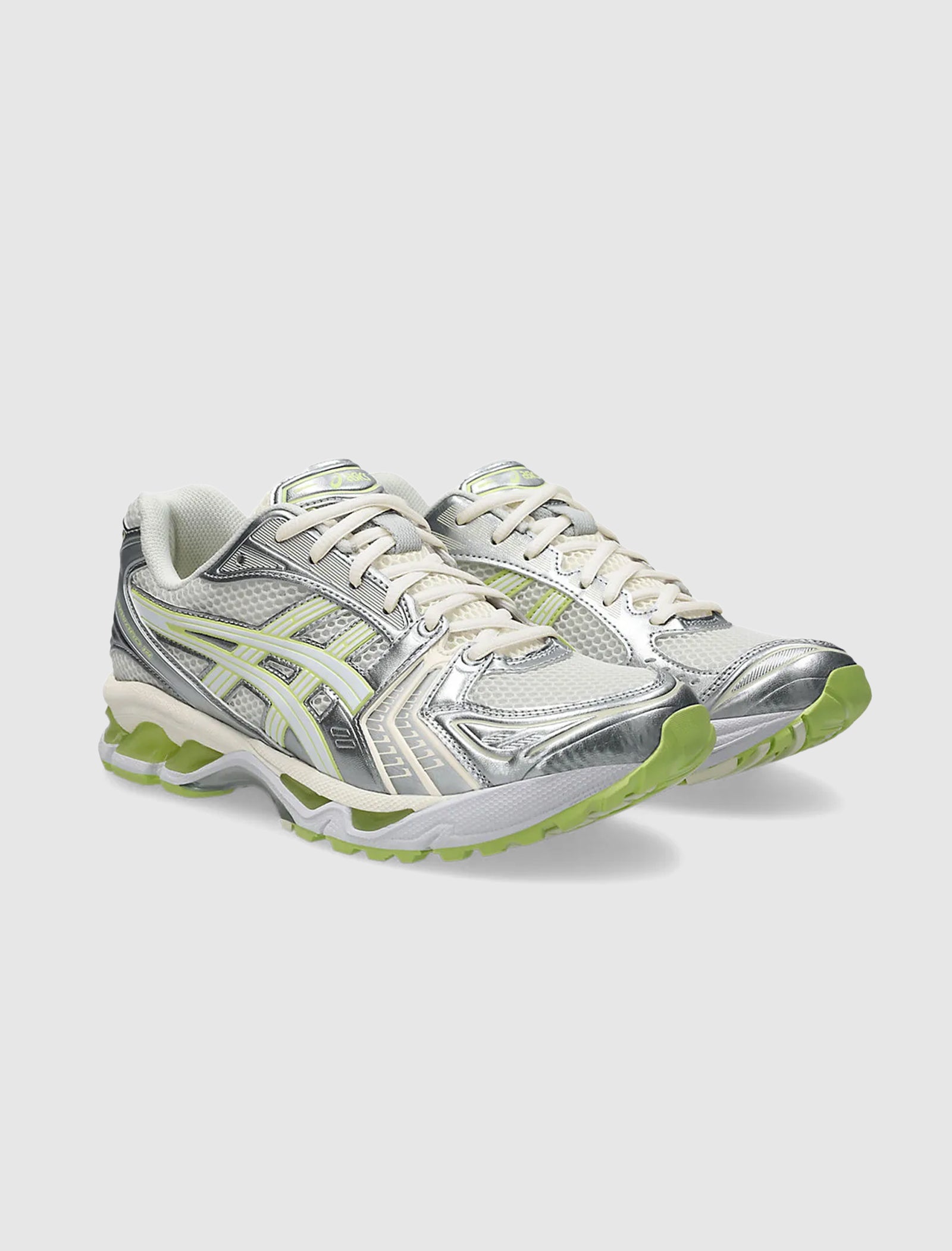A pair of silver and light green ASICS GEL-KAYANO 14 low top sneakers with white laces, mesh and synthetic uppers, neon green accents, gel midsoles, and chunky soles displayed on a plain light gray background.