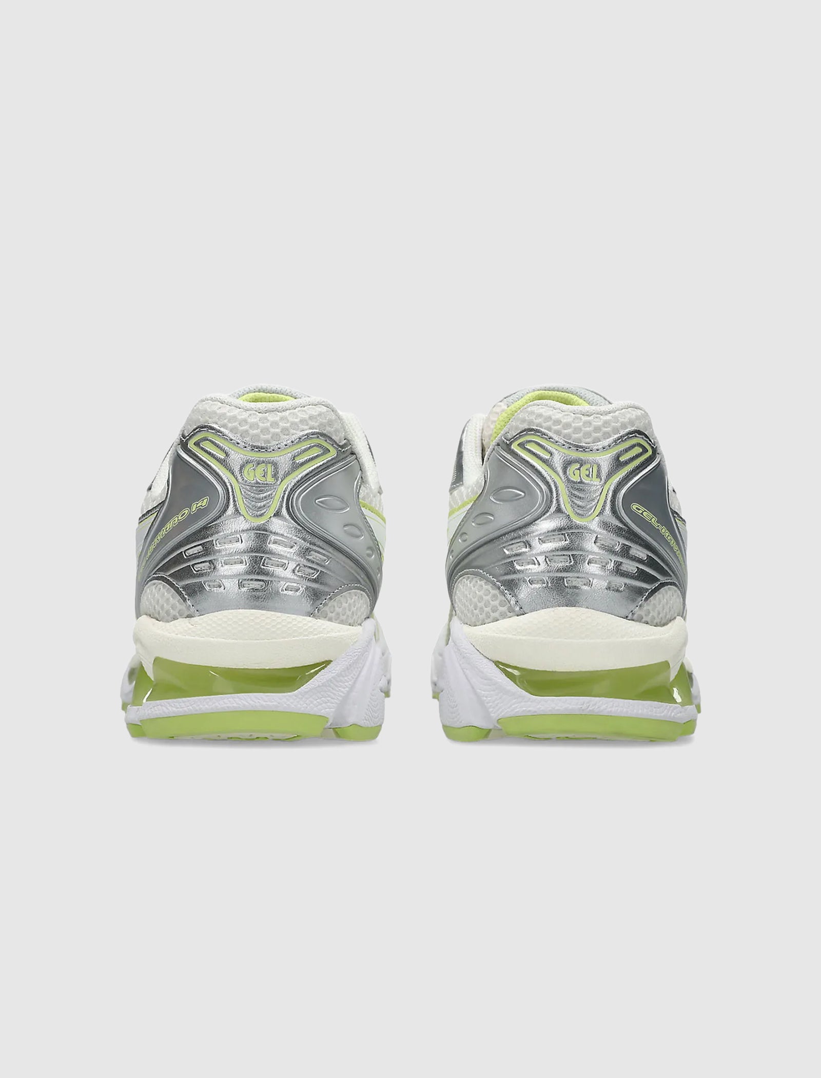 The GEL-KAYANO 14 showcases a synthetic upper in silver, white, and lime green, visible from the back. It features GEL branding, a gel-foam midsole for comfort, and textured heel details in a low top sneaker design.
