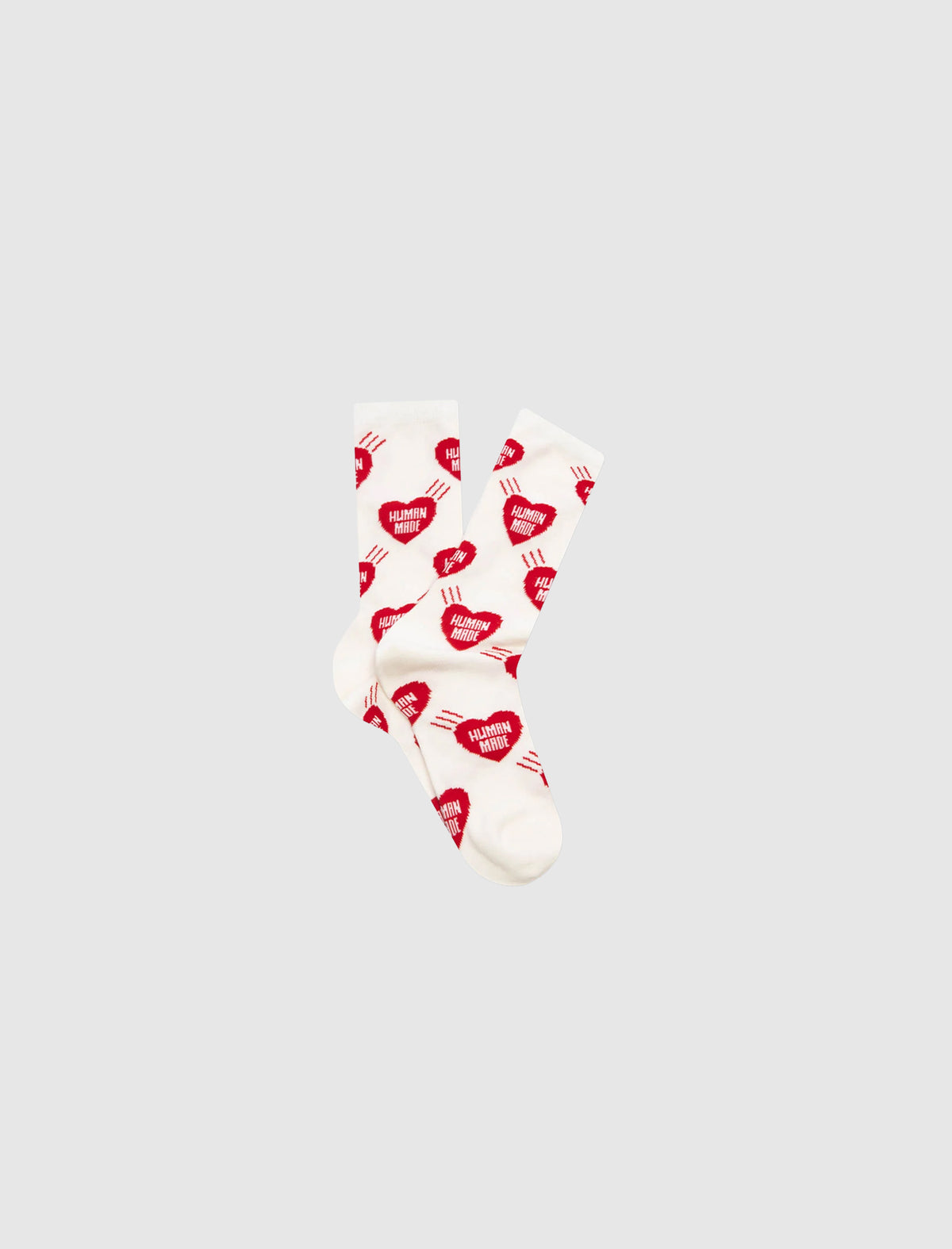 HEART SOCKS: white crew socks featuring a pattern of red Human Made heart logos, each containing the brand’s text.
