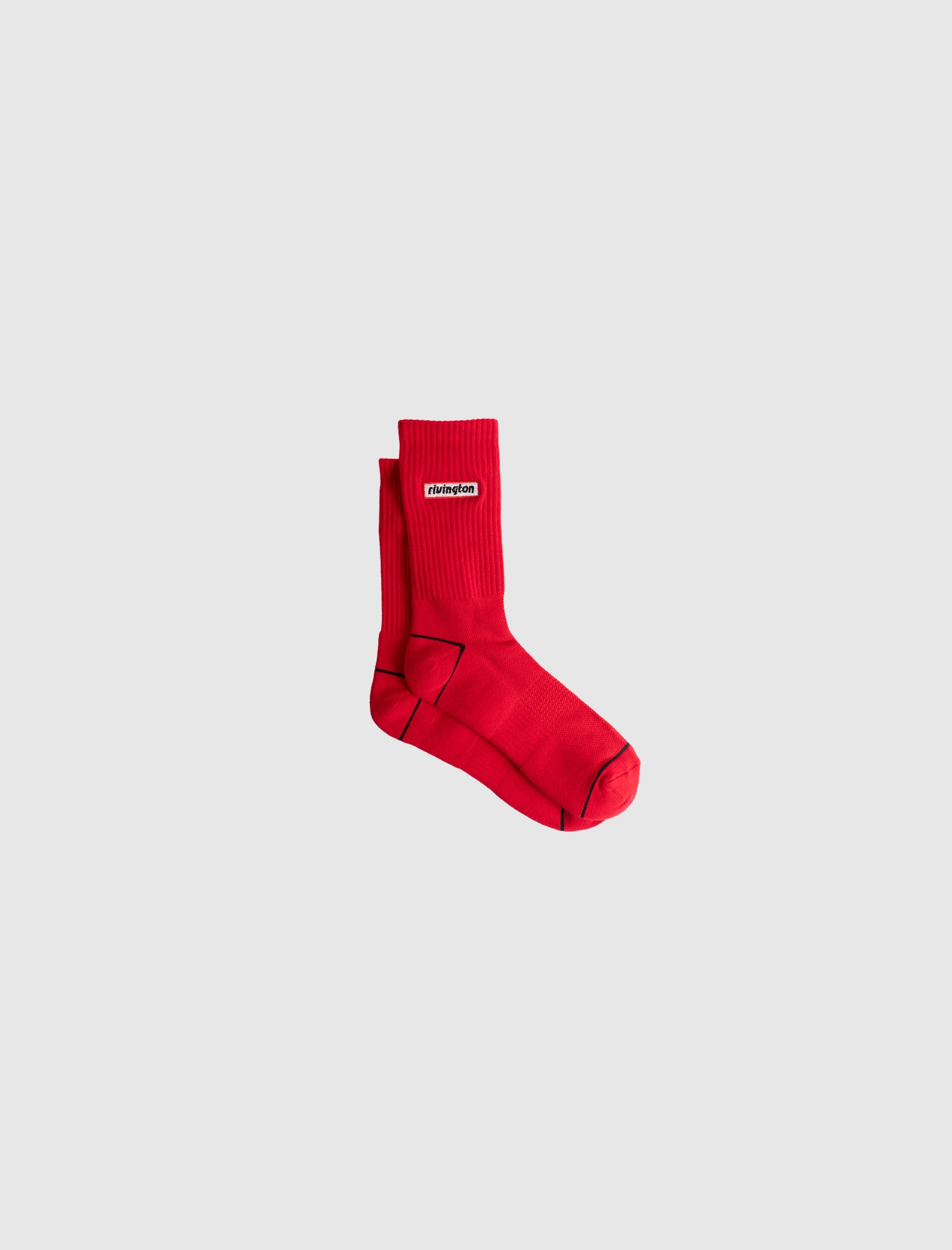 A pair of RIVINGTON SOCKS in bright red, featuring ribbed crew length design and a small white Champion label on the side, displayed against a plain light gray background.